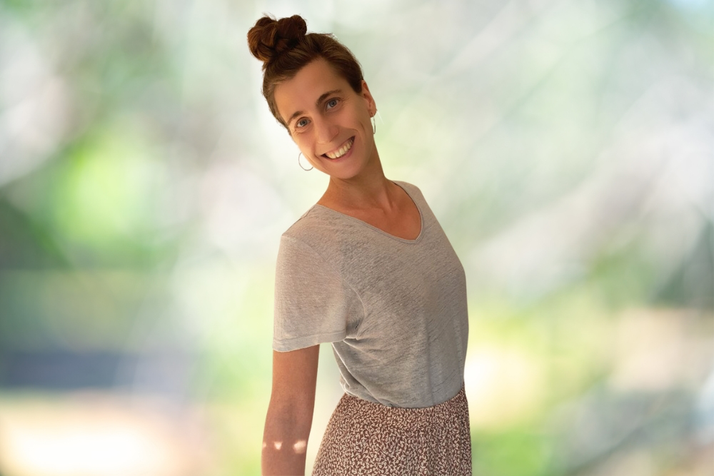 Catherina, Autorin des Blogs Wegweiser Neurodermitis, strahlt in hautfreundlicher Kleidung in die Kamera.